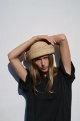 Sombrero de rafia 100%, de diseño tipo casquete con ala vuelta y tejido texturizado en tono tostado.
