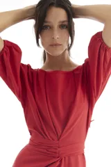 Vestido corto de lino color rojo, con mangas globo y escote redondo. Presenta un corte entallado en la cintura con un lazo ajustable que permite entallar la prenda.