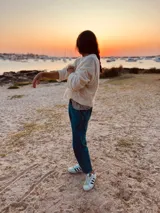 Sweater tejido en boucle color crema, de corte holgado y mangas largas.