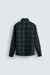 Camisa de corte regular fit confeccionada en tejido doble de algodón, con diseño de cuadros en tonos verde y azul marino. Presenta cuello solapa, manga larga con puño abotonado, bolsillo plastrón en el pecho y cierre frontal con botones.