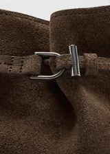 Bolso de mano tipo bandolera confeccionado en piel bovina de color marrón. Cuenta con un diseño estructurado, solapa frontal con detalle de trabilla y hebilla metálica, y asa corta para llevar al hombro o en la mano.