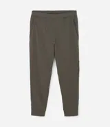 Pantalón deportivo de corte ajustado, confeccionado en tejido de poliéster texturizado color negro. Presenta cintura elástica con cordón de ajuste, bolsillos laterales con cierre y puños elásticos en los tobillos.