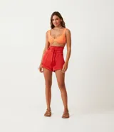 Short clochard de viscolino color beige, con cintura alta elastizada, bolsillos grandes aplicados en los laterales y detalle de cinturón de cuerda con borla.