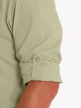 Camisa de manga larga color verde sage, confeccionada en popelina de algodón orgánico. Presenta cuello camisero, cierre frontal con botones de madera, bolsillo en el pecho con logo bordado y mangas ajustables con botones.