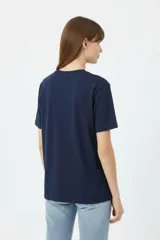 Remera negra de algodón con cuello redondo, manga corta y estampa frontal con texto en blanco.