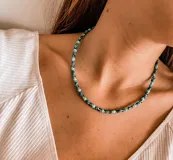 Gargantilla corta con cuentas de colores celeste, azul y plateado.