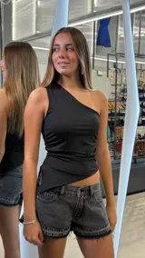 Top negro de un solo hombro, con diseño asimétrico en el ruedo y frunces laterales.