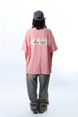 Remera de algodón peinado color rosa, de corte holgado y manga corta, con un pequeño bordado en el pecho.