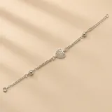 Pulsera de plata 925 con diseño de cadena doble, adornada con un dije central de corazón calado y dos esferas metálicas intercaladas.