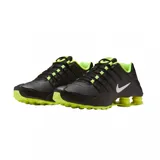 Championes Nike Shox NZ, de color negro con detalles en verde lima y el swoosh en blanco. Cuentan con sistema de amortiguación Shox en el talón y pasadores en la zona del empeine.