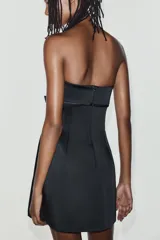 Vestido mini satinado negro con escote palabra de honor y detalle de lazo en el frente.