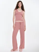 Pantalón de dormir de corte recto y holgado, confeccionado en tejido suave con textura acanalada. Presenta cintura elástica con cordón ajustable y bolsillos laterales.