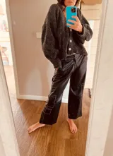 Pantalón cargo de cuero ovino negro con costuras blancas en contraste y corte suelto.