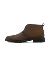 Bota corta de cuero marrón, estilo chukka o desert boot, con cordones y suela de goma negra gruesa y dentada.