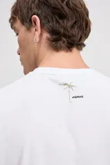 Musculosa oversize blanca de algodón, con sisas amplias y estampa frontal de inspiración tropical con palmeras y texto.