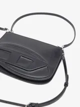 Cartera bandolera Diesel modelo 1DR Twin de cuero vacuno negro, con doble compartimento con cierre, correas desmontables y ajustables, y el distintivo logo Oval D en relieve en el frente.