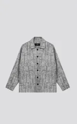 Campera de denim rígido con diseño de trama texturizada en tonos grises y negros. Presenta corte oversize, cuello camisero, cierre frontal con botones y dos bolsillos delanteros con solapa.