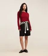 Suéter ajustado de punto color crema, con cuello redondo y mangas largas con botones metálicos en los puños. Confeccionado con viscosa sostenible.