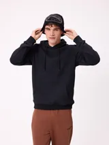 Gorro tipo beanie de punto color negro con diseño gráfico circular en gris en la parte frontal.