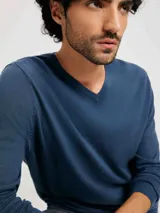 Sweater azul de tejido de punto con escote en V y mangas largas.