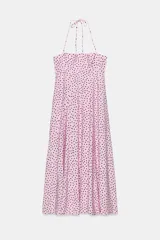 Vestido midi de color rosado con estampado de lunares negros, cuello halter con tirantes finos ajustables, escote recto y diseño fluido con volumen.