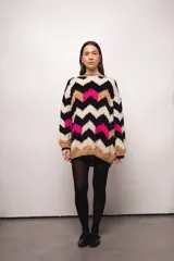 Buzo tejido a mano con lana merino, estilo oversized y diseño con patrón de ondas en colores blanco, negro, fucsia y marrón.