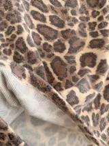 Buzo de cuello redondo y manga larga con estampado animal print de leopardo en tonos neutros.