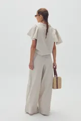 Pantalón de lino color natural, de corte palazzo y tiro alto.