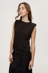Remera sin mangas negra con cuello redondo y hombros estructurados con hombreras, de corte recto y largo a la cintura.