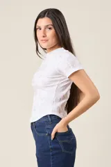Remera blanca con estampado tie-dye en tonos grises y logo "LOU JEANS" con apliques brillantes.