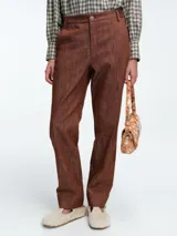 Pantalón de corte recto y tiro medio, confeccionado en denim de algodón con acabado texturizado en color tabaco. Presenta cierre frontal con botón y bolsillos laterales.