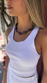 Musculosa blanca de algodón con cuello redondo y bordes en crochet color marrón.