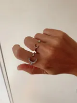 Anillo plateado ajustable con diseño de luna y estrella con incrustaciones de cristales brillantes.