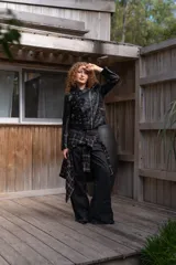 Campera de eco cuero negro con solapas anchas, cierre diagonal metálico y detalle de múltiples ojalillos metálicos distribuidos en el frente y las mangas.