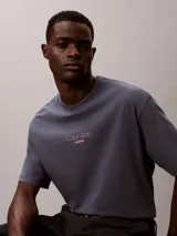 Remera Calvin Klein Jeans de corte holgado, color gris, con cuello redondo, mangas cortas y logotipo en relieve en el pecho.