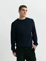 Sweater de punto inglés con escote redondo y mangas largas. Presenta cuello y puños terminados en punto canalé.
