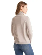 Polera de tejido fino, color rosado, con cuello alto, manga larga y detalle de tajo en los puños.