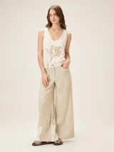 Top de escote en V color blanco, confeccionado en algodón con spandex, de calce cómodo y femenino, con detalle artesanal de flor bordada.