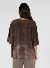 Remera color amarillo con cuello redondo y mangas cortas anchas con detalle de botones en los laterales. Diseño holgado con efecto gastado.