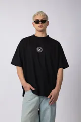 Remera negra oversize de algodón premium con cuello redondo y mangas cortas. Presenta un logo bordado en el frente y un parche estampado en la espalda.
