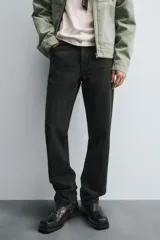 Pantalón de jean corte slim fit, color gris con efecto lavado. Presenta diseño de cinco bolsillos, cierre frontal con cremallera y botón, y tejido elástico.