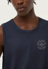 Musculosa de hombre color beige, de corte clásico y sin mangas, con pequeño estampado tipográfico en el pecho.