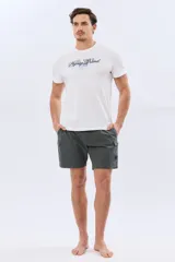 Short de baño cargo color negro, de diseño liso con bolsillos laterales y bolsillos utilitarios con solapa y botón en las piernas. Cuenta con cintura elástica ajustable mediante cordón.