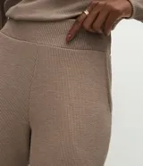 Pantalón recto color marrón de tejido anarruga, con cintura elástica ancha y bolsillos laterales funcionales.