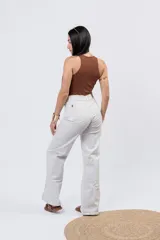 Body de algodón suave y elastizado de color blanco, con cuello a la base tipo halter y diseño cavado de tiro alto.