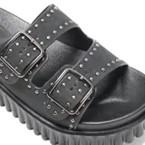 Sandalias plataforma tipo mule color negro, con dos tiras frontales ajustables con hebillas cuadradas y detalles de tachas metálicas. Cuenta con suela alta texturizada.