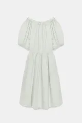 Vestido midi confeccionado en lino 100%, con escote recto elástico estilo hombros descubiertos, mangas abullonadas y detalle de pliegues en la cintura. Cuenta con bolsillos laterales ocultos y bajo asimétrico.