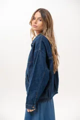 Campera de jean azul de silueta relajada, con cuello clásico, cierre frontal con cremallera metálica y bolsillos laterales.