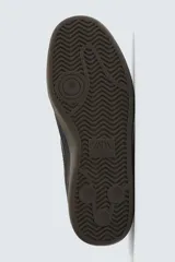 Zapatilla deportiva de estilo retro con diseño de paneles combinados en tonos beige y crema. Presenta detalles en gamuza y una suela de goma en color caramelo.