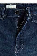 Jean wide leg de tiro alto en denim de algodón azul, con costuras frontales verticales y bolsillos simulados con solapa y botones en la parte delantera.